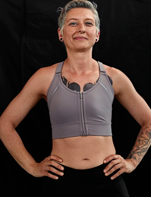Women with tattoos smiling whilst wearing the Athleta Empower Bra